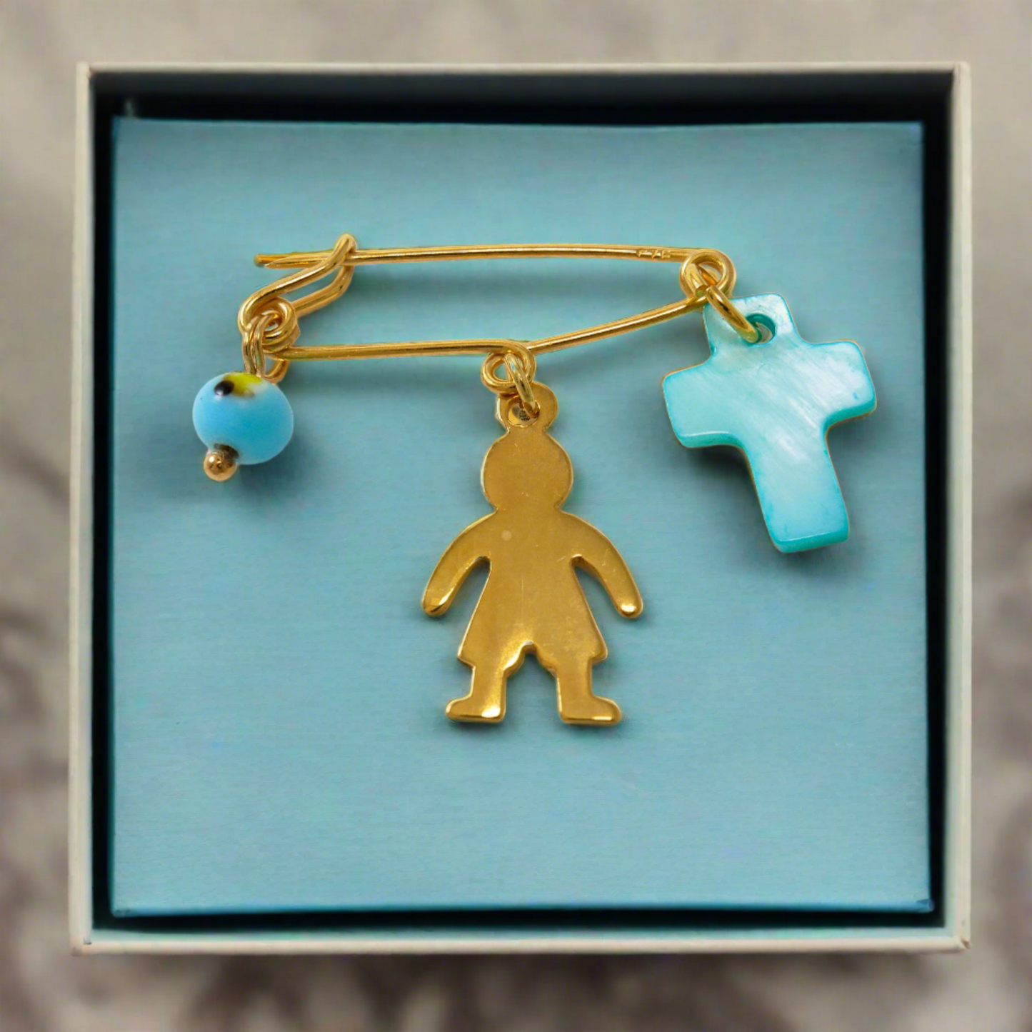 ng silver pin with a boy an evila eye and a turqoise cross