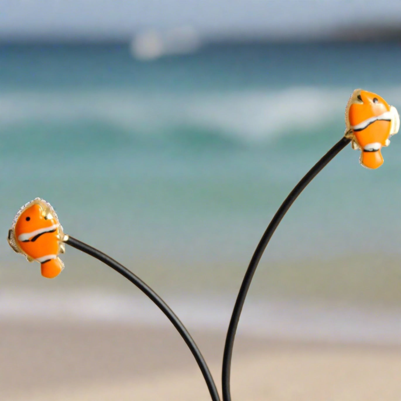  18K gold earrings feature a playful fish-nemo adorned with vibrant enamel