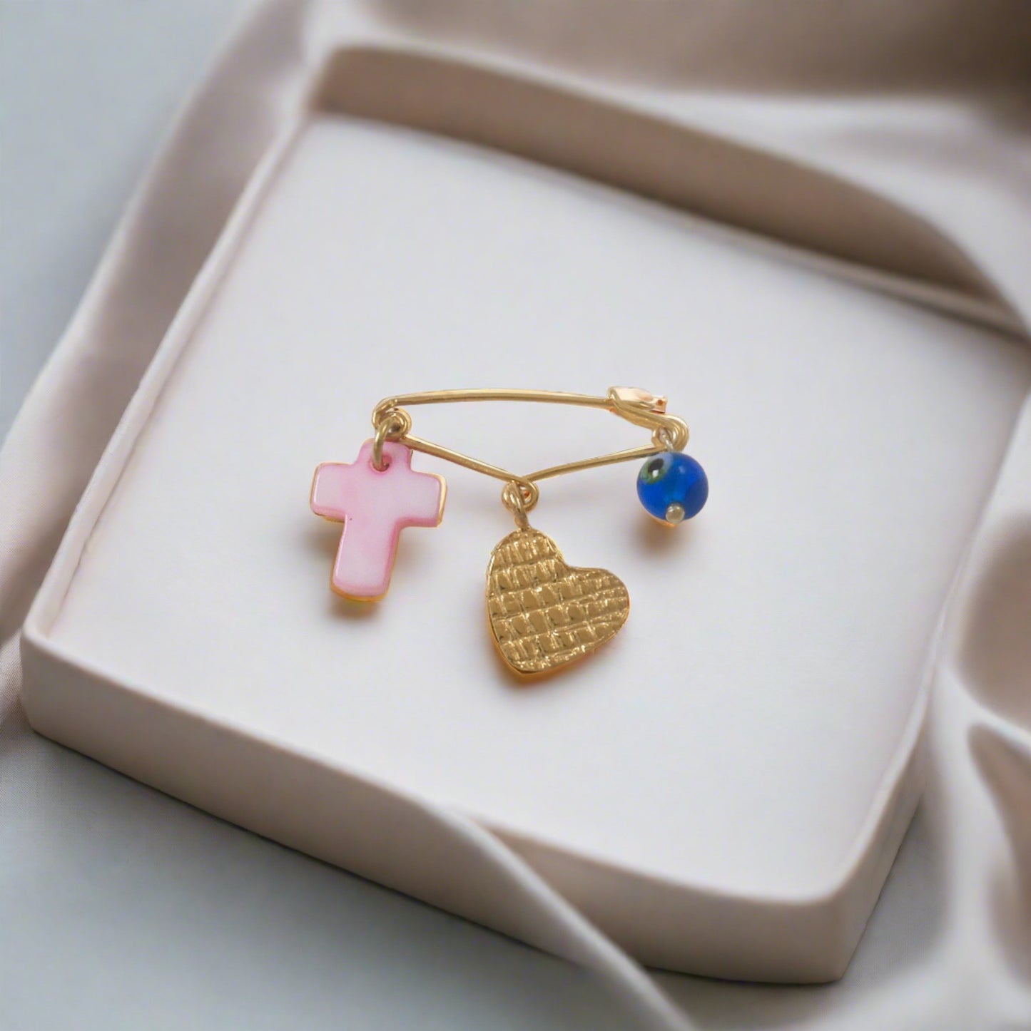 Gold plated sterling silver pin with a heart, a pink cross and an evil eye