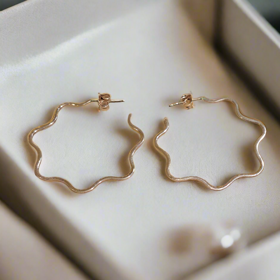 14K Red gold wavy hoops in a luxury jewelry box
