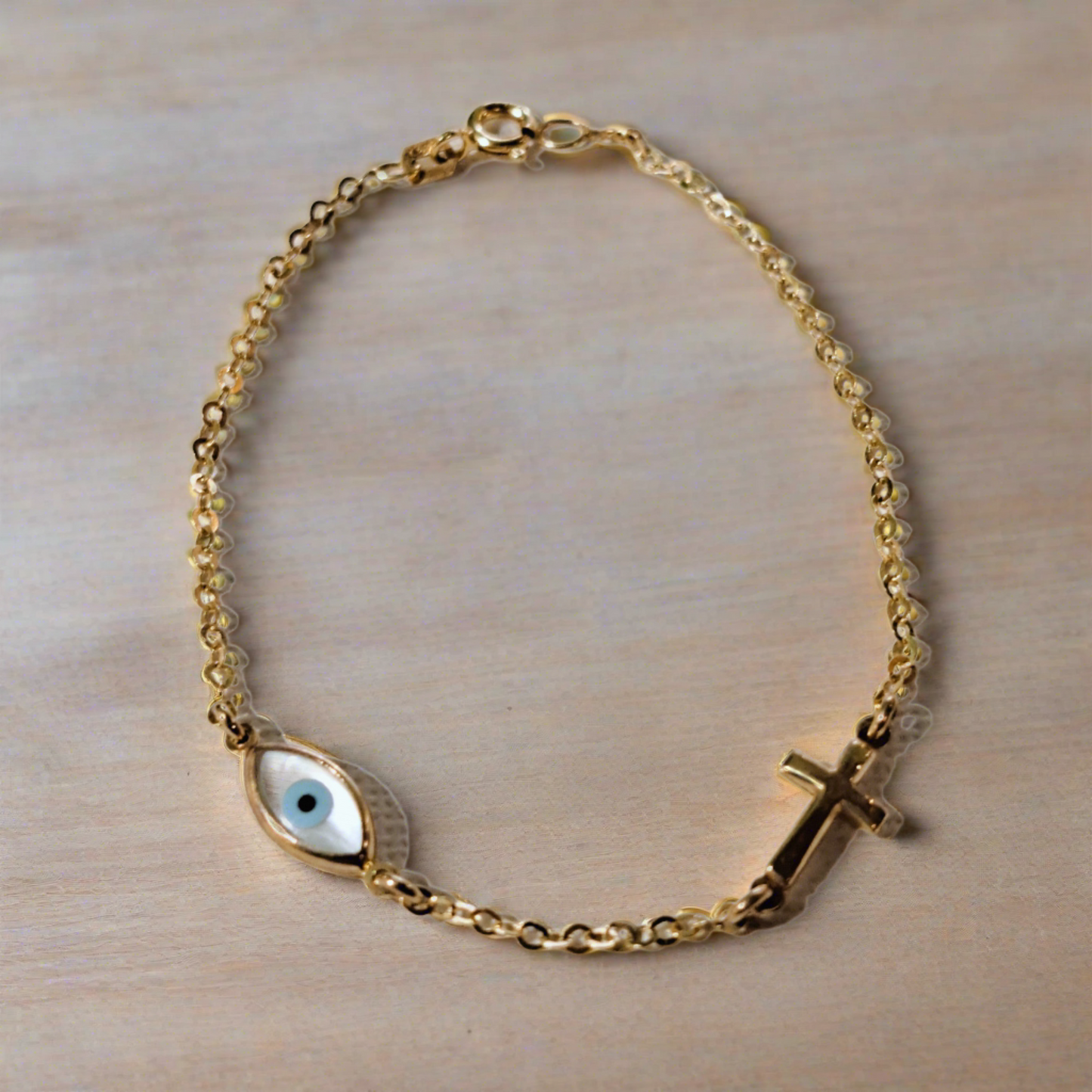14K Gold bracelet with evil eye and a cross.