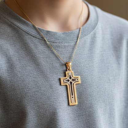 Gold cross pendant on a chain against a gray shirt background
