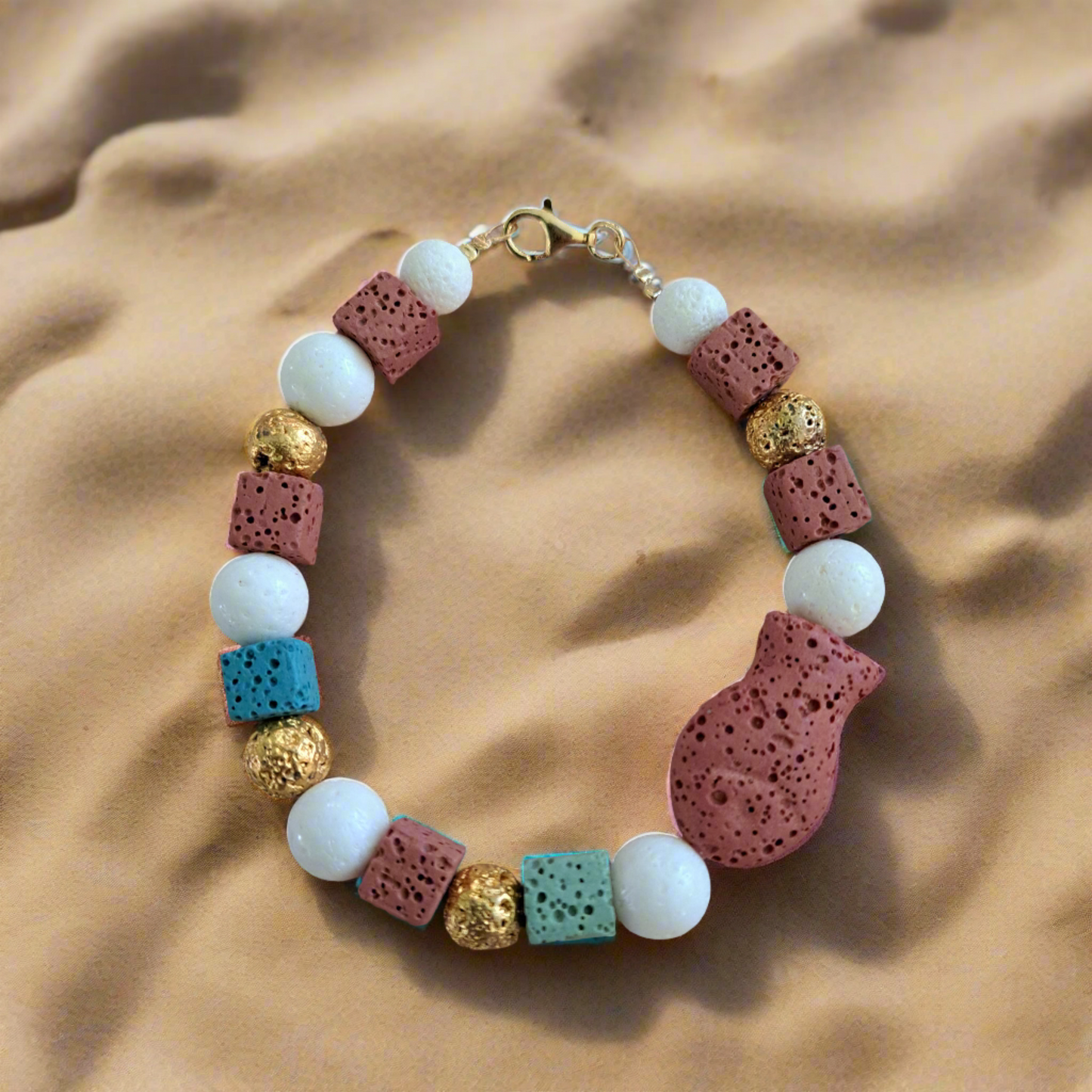 Handmade bracelet with white corals, lawa beads and goldplated sterling silver elements.