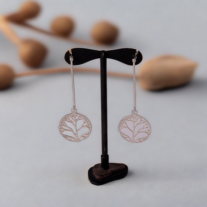 Tree of life long earrings in a stand . Earrings made of silver, gold-plated, long with thick wire, and beneath the wire hangs a round design with the tree . The design is  very elegant.”