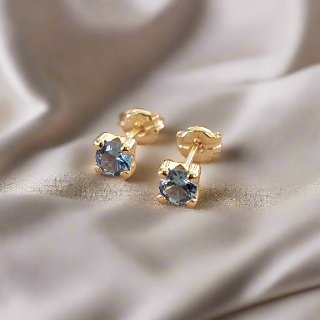  9Κ Gold earrings with blue zirkons on a luxury cloth