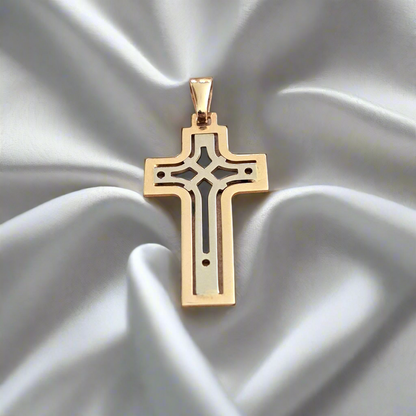 A 14k white and gold cross pendant displayed on a silky surface.