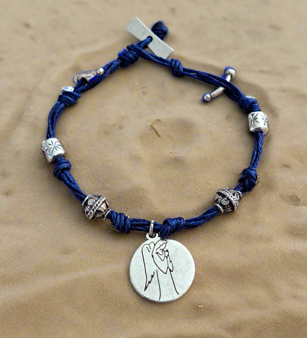 Blue braided bracelet with gernan silver beads and a circular pendant with the angel of success