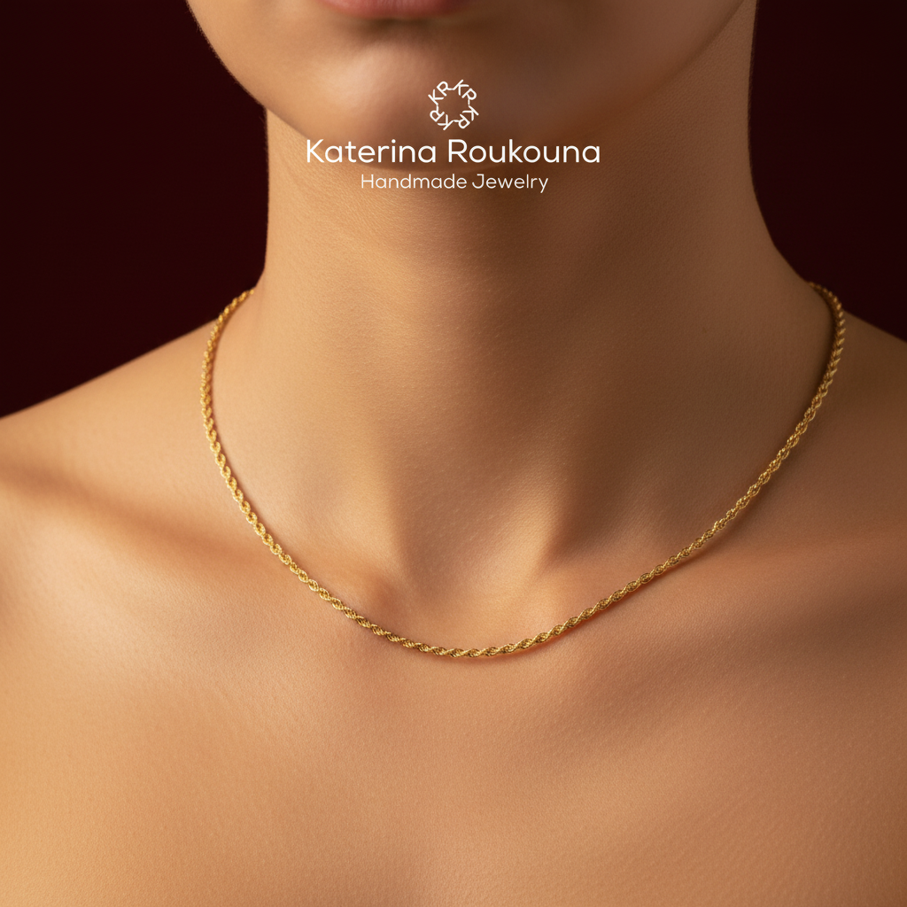 A close-up of a model's neck and upper chest wearing a delicate twisted gold chain necklace. The brand logo 'Katerina Roukouna Handmade Jewelry' is displayed at the top center against a dark warm brown background.