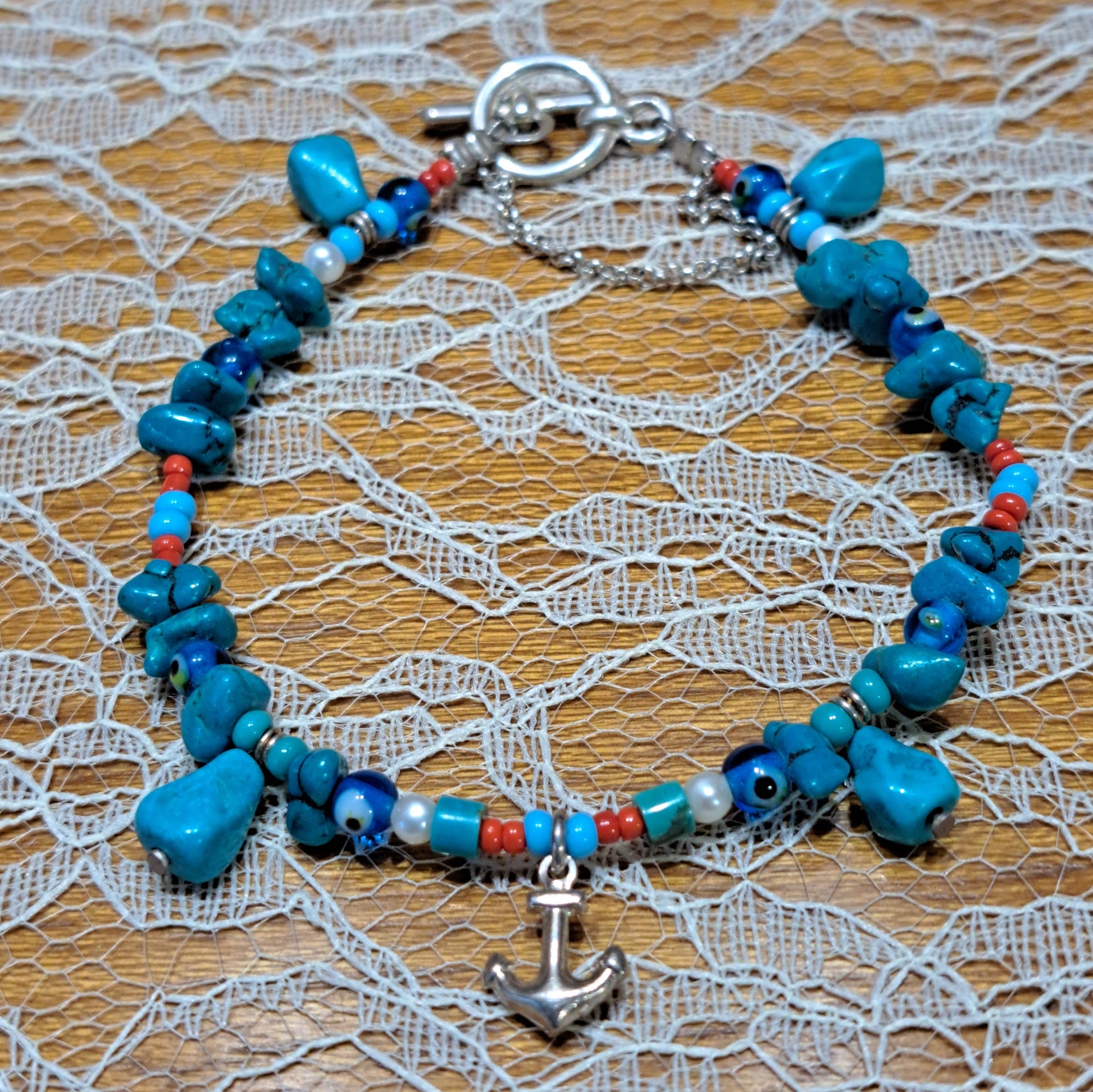 A bracelet with turqoise beads pearls  steling silver anchor and clasp