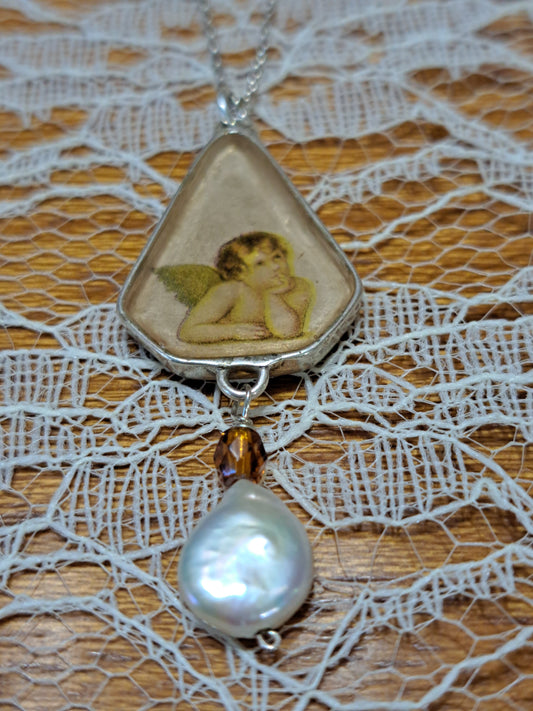 Sterling silver pendant with an angel and a pearl.