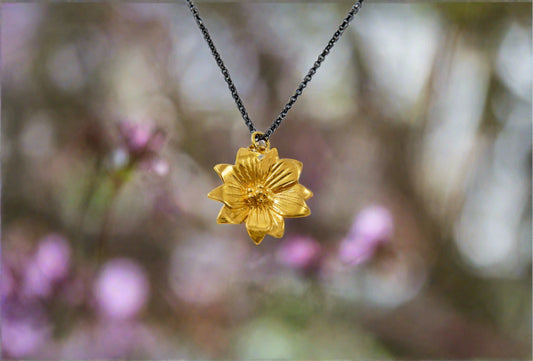 Gold plated sterling silver chrycanthemum flower in a black siver chain