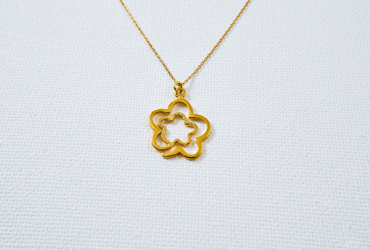 A flower in a flower gold plated sterling silver nevklace.